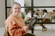© AnnaStills - Medium close up portrait of Caucasian woman with down syndrome holding clipboard with documents