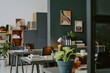 © AnnaStills - Modern and minimalist office with abstract pictures on gray walls, wooden furniture and workplaces decorated with plants
