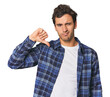 © Asier - Young Hispanic man in studio showing thumb down, disappointment concept.