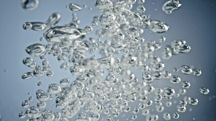 Wall Mural - super slow motion shot of air bubbles rising up in water on light blue background at 1000fps.