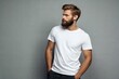 © DND - Male model with a beard wearing a blank white T-shirt with space for logo or design. on grey background.