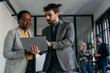 © La Famiglia - Focused colleagues reviewing important data on a tablet in a bright workspace
