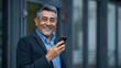 © Studicon - A man is smiling and holding a cell phone