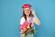 © New Africa - Beautiful teenage girl with bouquet of tulips on light blue background