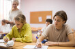 © JackF - Portrait of teenage school girl and boy sitting together in classroom during lesson in secondary school