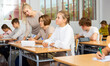 © JackF - Group of teenage girls and boys exercising during lesson in classroom.