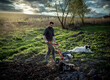 © Melinda Nagy - organic farming man ploughs the ground at sunset with a tiller preparing the soil for sowing