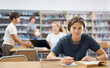 © JackF - Teenage boy reading books and doing homework in library.