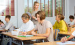 © JackF - Group of diligent school kids and teacher during lesson in classroom in secondary school