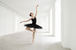 © Andriy Bezuglov/Stocksy - Ballet dancer posing inside light empty space