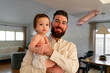 © Christine La/Stocksy - Father holding baby