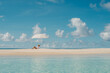 © Alina Hvostikova/Stocksy - Relaxing under an umbrella on a tranquil beach