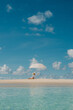 © Alina Hvostikova/Stocksy - Relaxing under a white umbrella on a sunny beach day