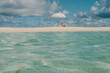 © Alina Hvostikova/Stocksy - Relaxing by the clear blue ocean under a parasol on the beach