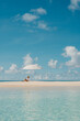 © Alina Hvostikova/Stocksy - Relaxing on the beach under a sun umbrella by the clear ocean