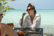 © Alina Hvostikova/Stocksy - Enjoying a tropical lunch by the clear blue ocean shore