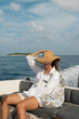 © Alina Hvostikova/Stocksy - Woman enjoying a boat ride on a sunny day near an island