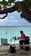 © Alina Hvostikova/Stocksy - Relaxing at a beachside table in Rasdhoo, Maldives