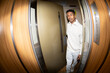 © Jimena Roquero/Stocksy - Young man entering elevator in building. Fisheye. Direct flash.