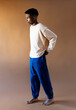 © Jimena Roquero/Stocksy - Studio full body portrait of young man standing over ochre background