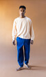 © Jimena Roquero/Stocksy - Studio full body portrait of young man standing over ochre background