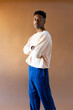 © Jimena Roquero/Stocksy - Studio portrait of young man standing over ochre background