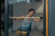 © Alina Hvostikova/Stocksy - LGBTQ builder works on home repairs in a sunny construction site