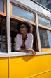 © tessy morelli/Stocksy - Stylish woman listening music on Yellow Lisbon tram