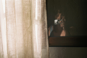 Shadowed reflection behind textured linen curtain