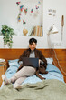 © Jimena Roquero/Stocksy - woman in bedroom using computer smiling