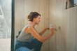 © Alina Hvostikova/Stocksy - Builder working on wall repairs in a construction space