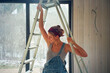 © Alina Hvostikova/Stocksy - LGBTQ builder working on home repairs in a bright space