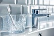 © Frame Nest - Closeup pf glass cup and toothbrush placed on washbasin in bathroom interior with grey tile walls