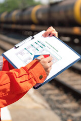 Wall Mural - action of an engineer is checking on the chemical hazard material form with background of crude oil 