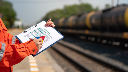 Wall Mural - action of an engineer is checking on the chemical hazard material form with background of crude oil 