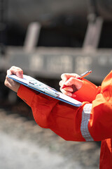 Wall Mural - action of an engineer is checking on the chemical hazard material form with background of crude oil 