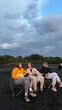 © Alina Hvostikova/Stocksy - Friends gather on a black sand beach at sunset discussing life
