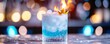 © Wimon - Frosty blue coconut and vanilla rum cocktail, beautifully contrasted with a bright yellow flame, glowing under a wintry ice-blue bokeh effect.