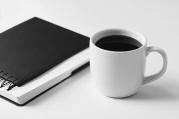 Poster - A cup of coffee sits next to an open notebook, perfect for morning inspiration