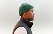 © VICTOR TORRES/Stocksy - Profile of black man in green beanie and black jacket