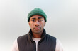 © VICTOR TORRES/Stocksy - Portrait of a young black man in casual attire with green beanie