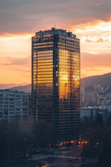 Aufkleber - Cityscape with the sun setting behind a tall building