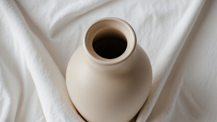 Poster - Minimalist beige ceramic vase with slender neck on a white fabric backdrop top view emphasizing modern design and home decor elegance.