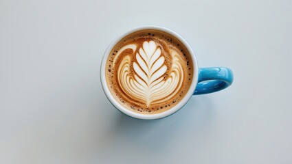 Poster - Cappuccino with intricate latte art in a light blue coffee cup viewed from above, placed on a clean white background, showcasing barista skill.
