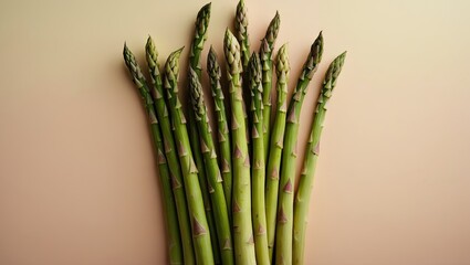 Aufkleber - Fresh green asparagus spears clustered on a soft pastel beige background with vibrant green colors highlighting the tips at an angle.