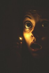 Aufkleber - A person holds a lit candle in front of their face, creating an intimate and mysterious atmosphere