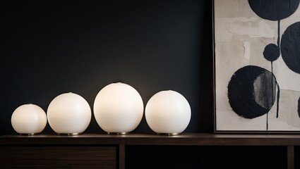 Poster - Elegant arrangement of round soft white lamps on a dark wooden surface against a black wall showcasing abstract black and white artwork.