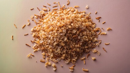 Poster - Dried shallot flakes scattered on a soft pastel gradient background with beige and light pink hues, showcasing texture and natural color.