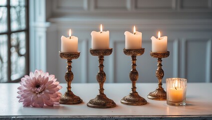 Aufkleber - Elegant gold candlesticks with lit white candles arranged in a line on a bright white table with a pink flower and a glowing candle to the side.