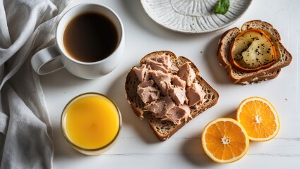 Poster - Vegan tuna spread on whole grain bread with coffee and orange juice on a white tabletop garnished with mint leaves and orange slices.